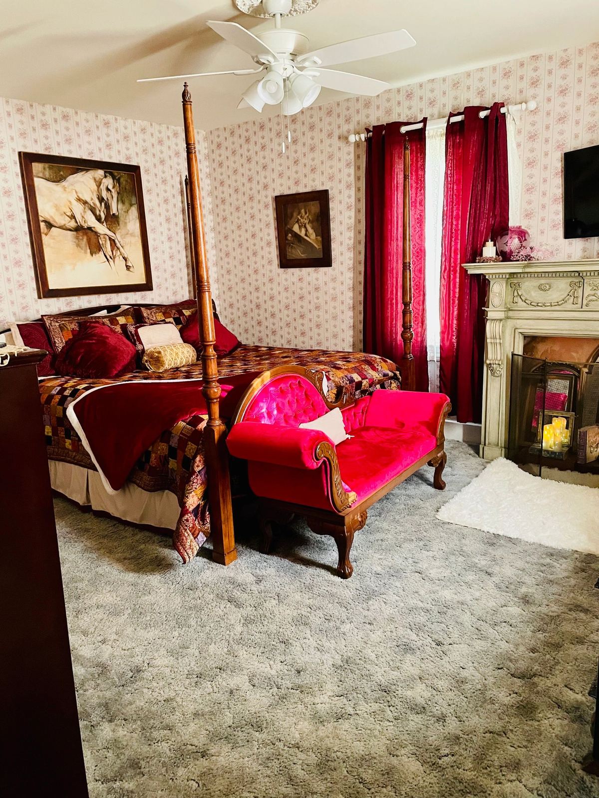 Anthracite Room: four-poster bed, red curtains, and a fireplace with candles